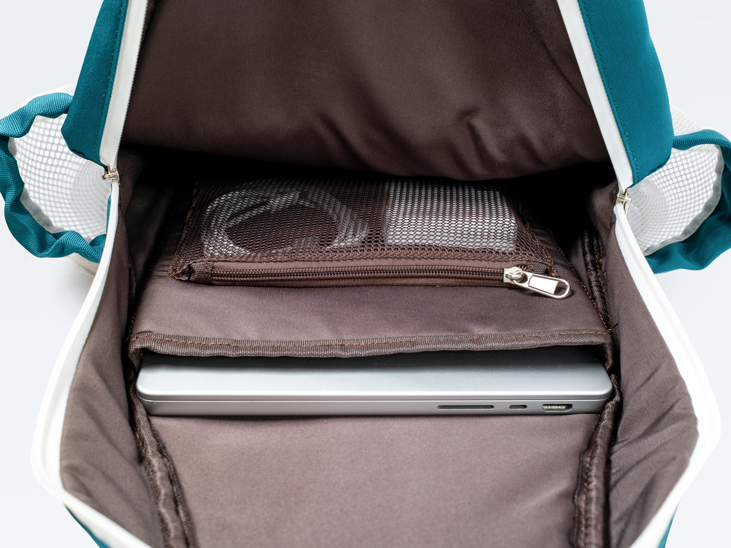 Open padel backpack with a laptop inside, showing storage compartments and pockets